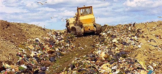 Garbage being rearranged at a landfill site.